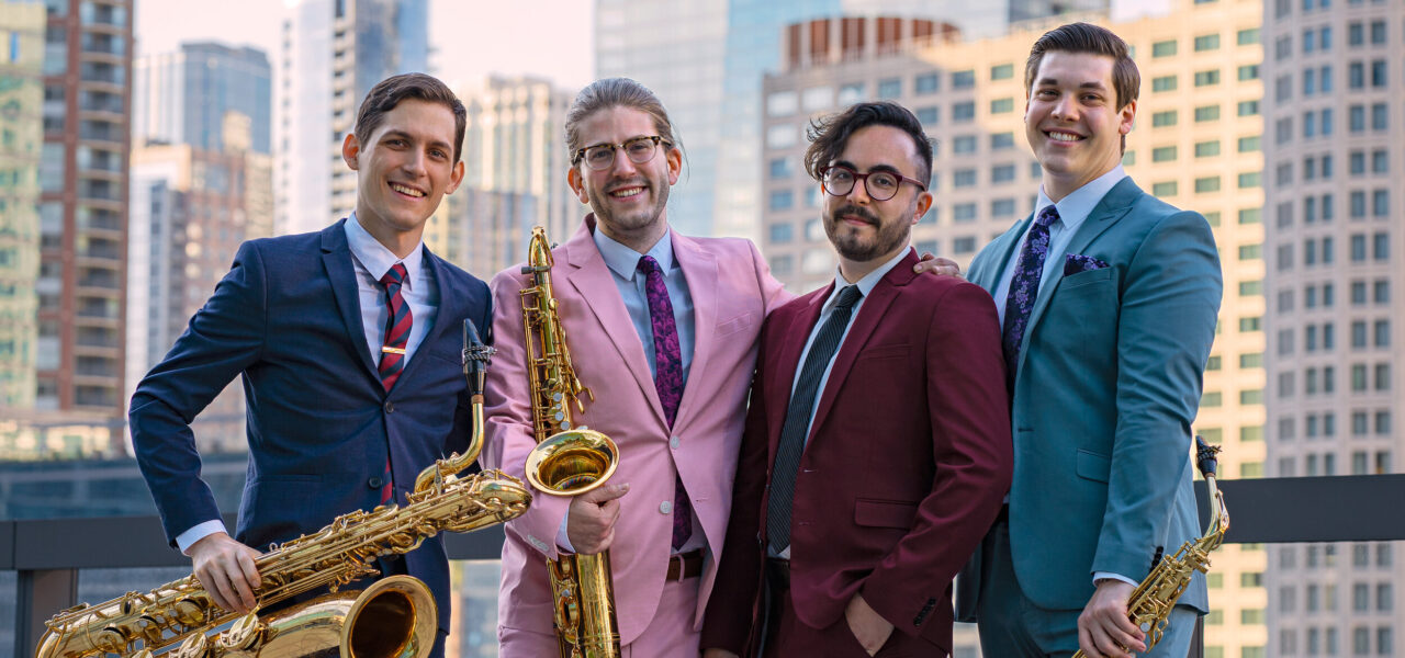 for members of the ~Nois saxophone ensemble. Each member is standing and holding a saxophone, with a blurred city skyline in the background.