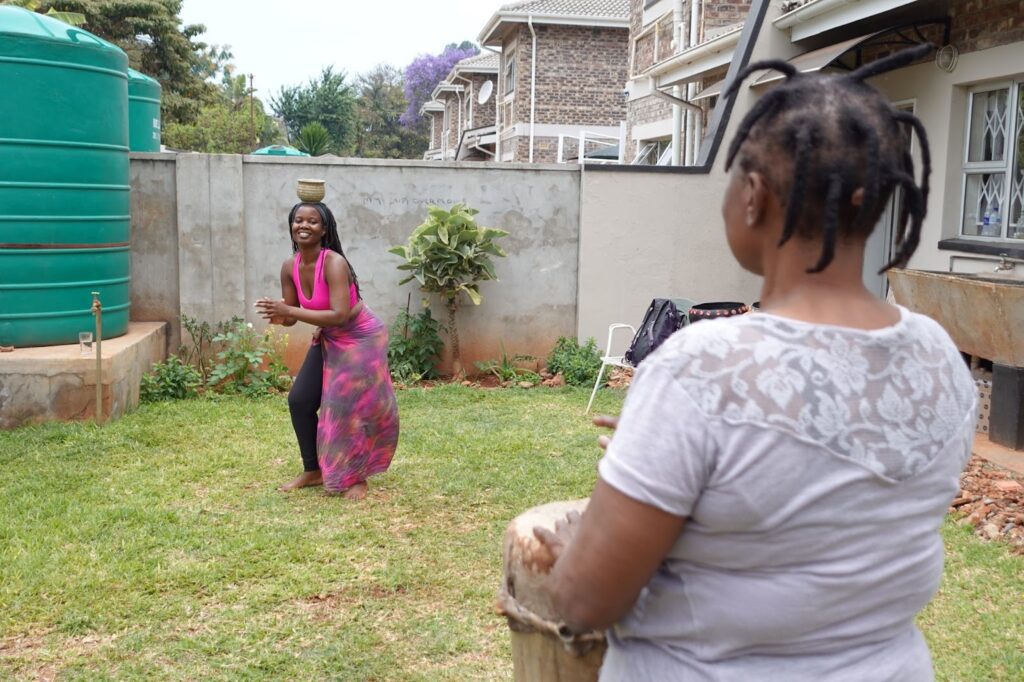 Two women, one dancing while the other watches.