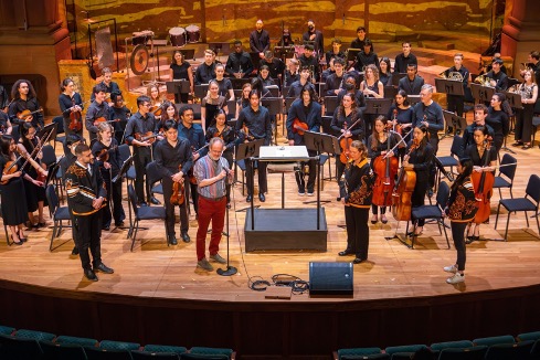 Orchestra members standing on the stage