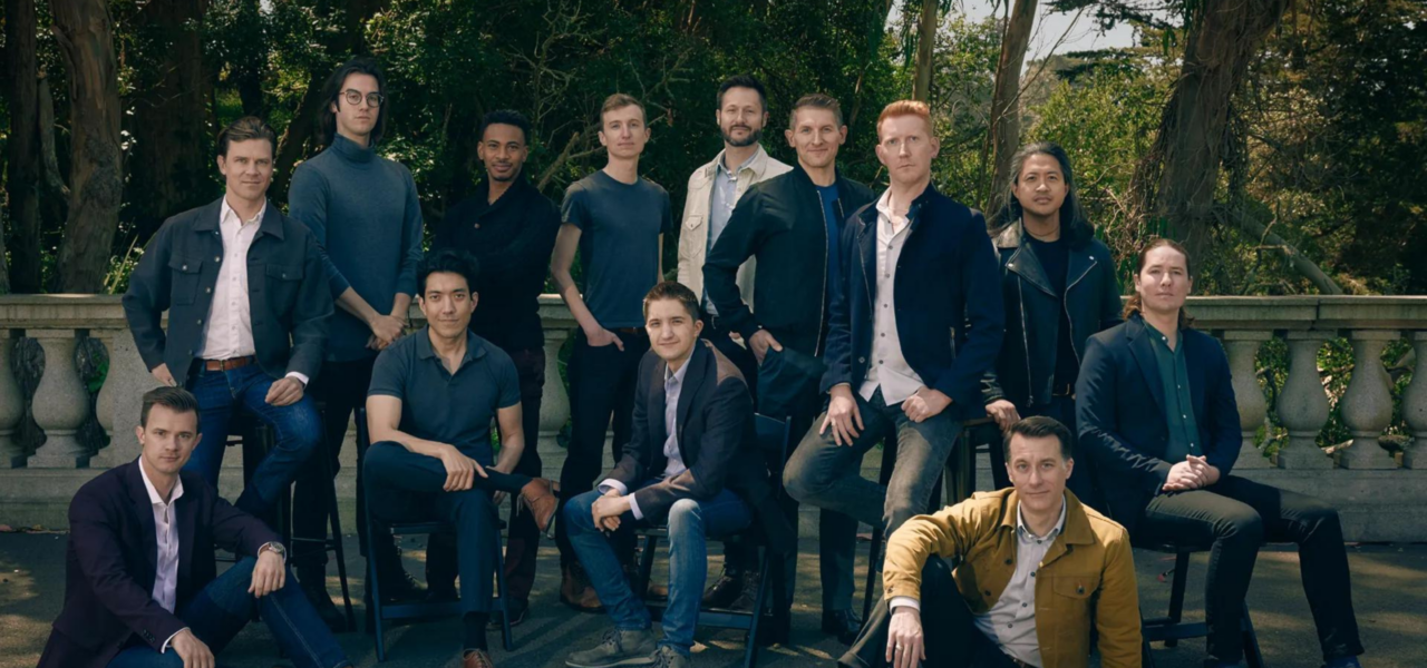 members of the CHANITCLEER vocal ensemble posed outside, with a mix of people standing and sitting