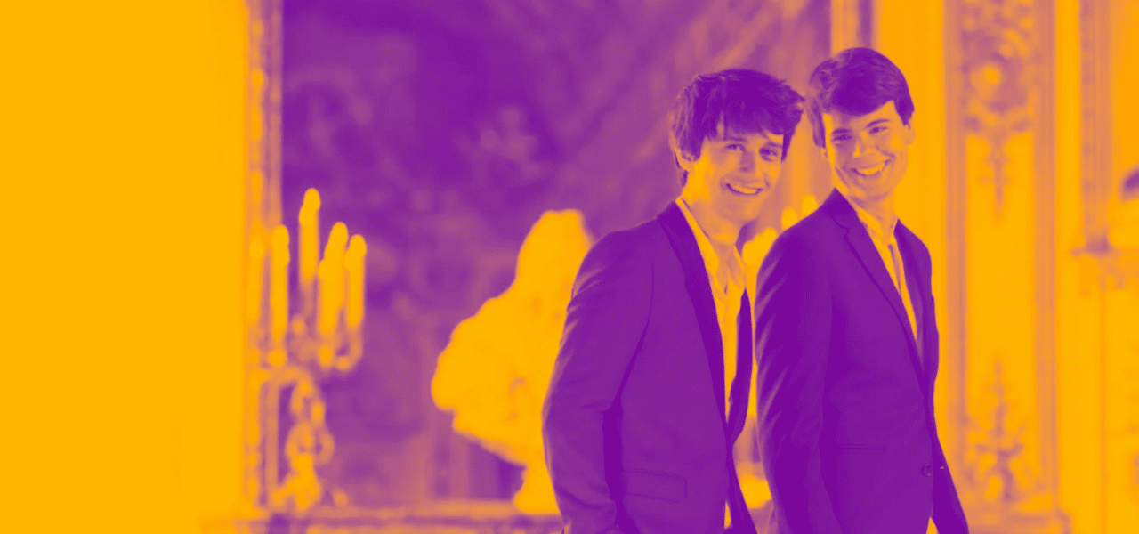 two musicians (Théotime Langlois de Swarte and Justin Taylor) standing side by side, smiling at the camera