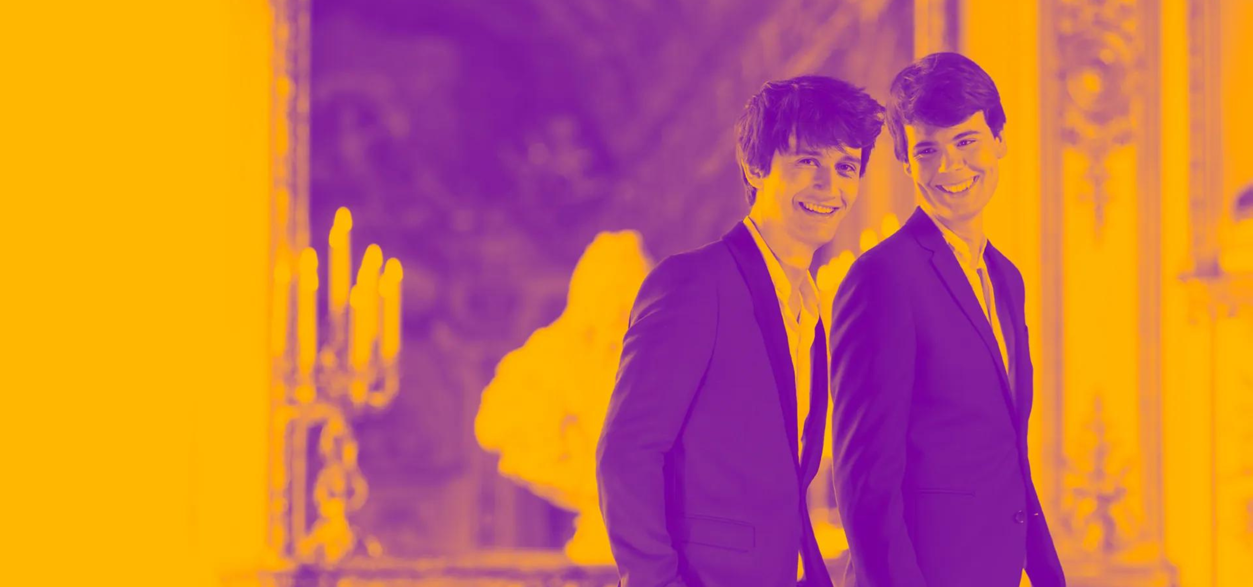 two musicians (Théotime Langlois de Swarte and Justin Taylor) standing side by side, smiling at the camera