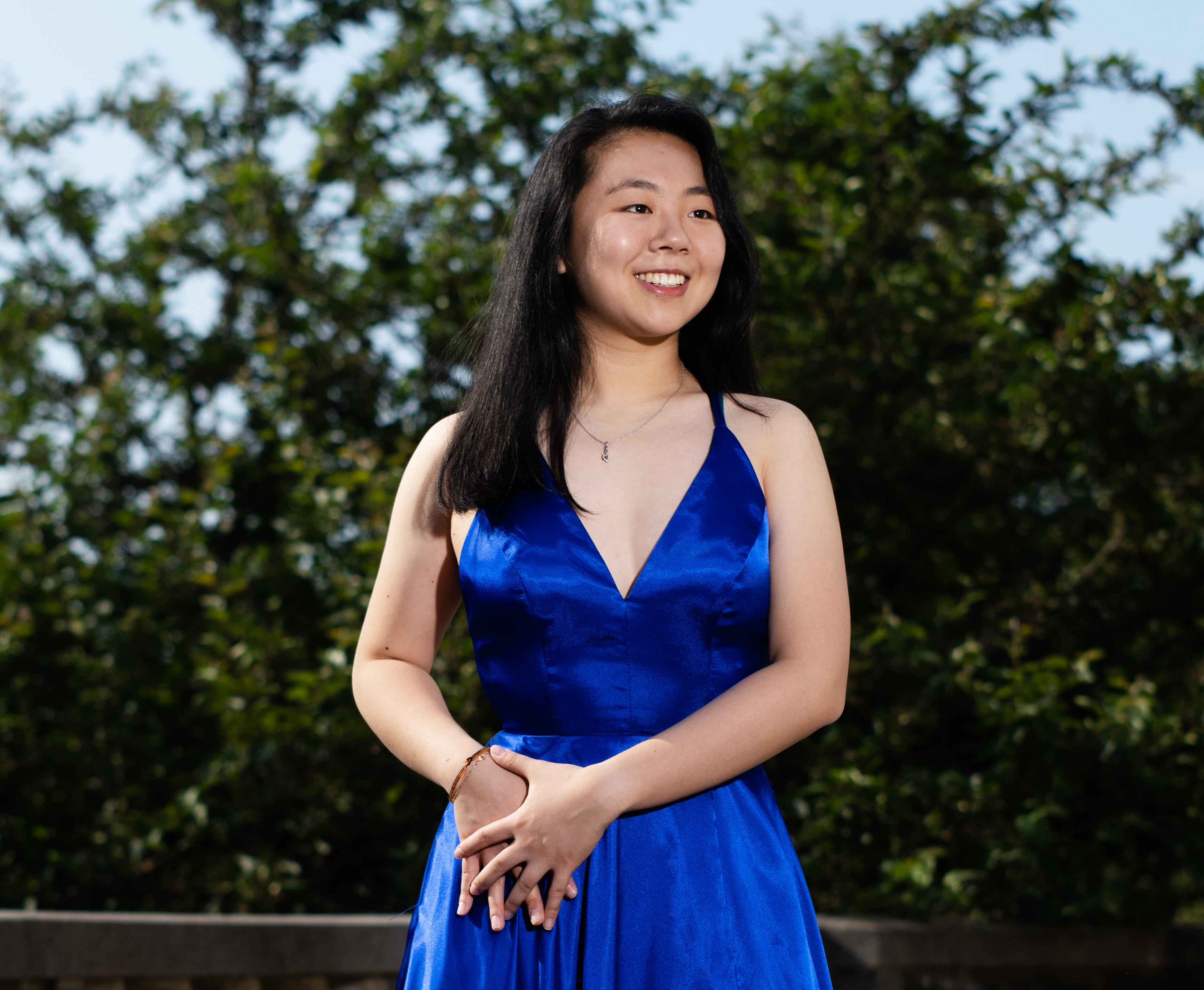 A woman standing outside wearing a blue dress