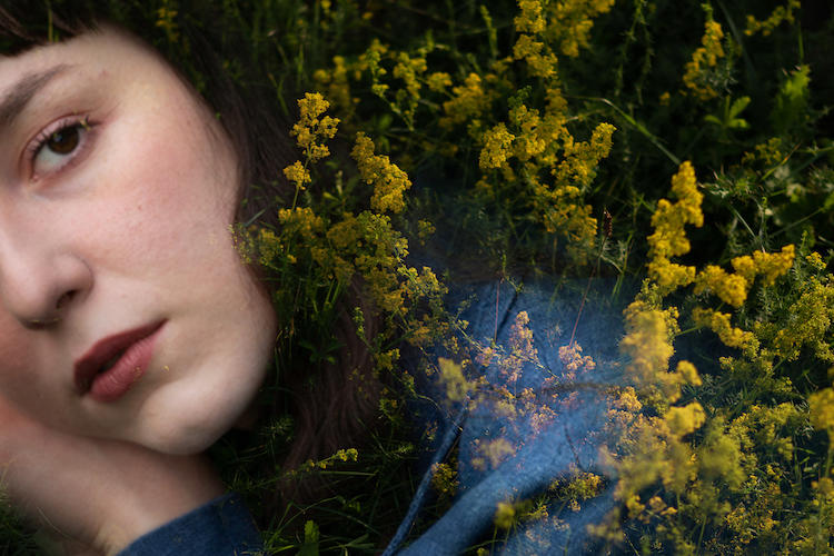 Artsy image of Alkyone's face partially visible and bordered by small yellow flowers